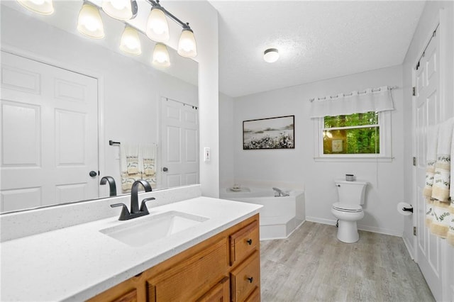 3012 Cypress Cv, Ball Ground, GA 30107 - bathroom with vanity, a bath, wood finished floors, a textured ceiling, and baseboards