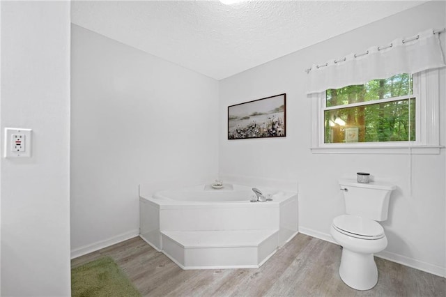 3012 Cypress Cv, Ball Ground, GA 30107 - full bath featuring wood finished floors, a bath, toilet, a textured ceiling, and baseboards