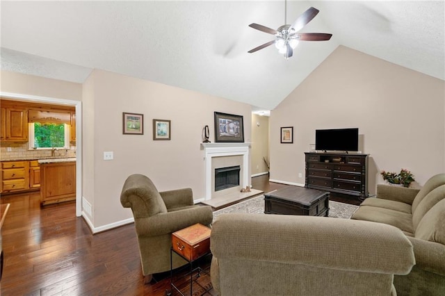 3012 Cypress Cv, Ball Ground, GA 30107 - living room with ceiling fan, dark wood-type flooring, a fireplace with raised hearth, lofted ceiling, and baseboards