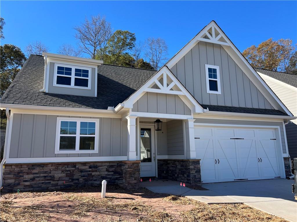400 Maple View Dr, Carrollton, GA 30117 - craftsman house featuring board and batten siding, a garage, a shingled roof, and stone siding