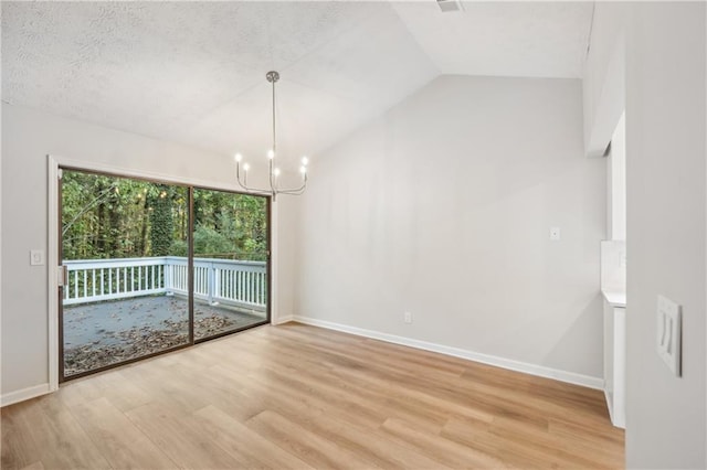 unfurnished dining area featuring a notable chandelier, a textured ceiling, lofted ceiling, and light wood-type flooring