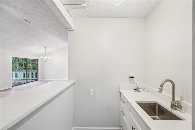 bathroom featuring vanity, a textured ceiling, a notable chandelier, and wood-type flooring