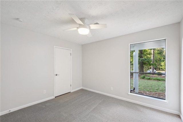 carpeted spare room featuring a textured ceiling and ceiling fan