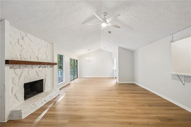 unfurnished living room featuring a textured ceiling, wood-type flooring, a fireplace, and vaulted ceiling