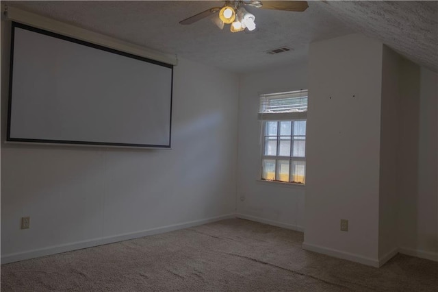 carpeted home theater featuring vaulted ceiling, ceiling fan, and a textured ceiling