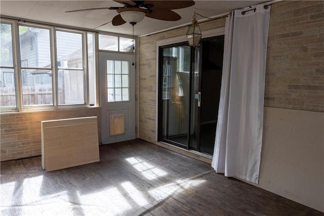 unfurnished sunroom featuring ceiling fan