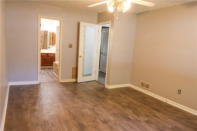 unfurnished bedroom with a textured ceiling, ceiling fan, and dark wood-type flooring