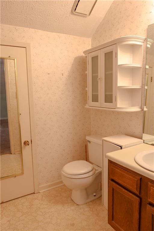 bathroom with vanity, a textured ceiling, vaulted ceiling, and toilet