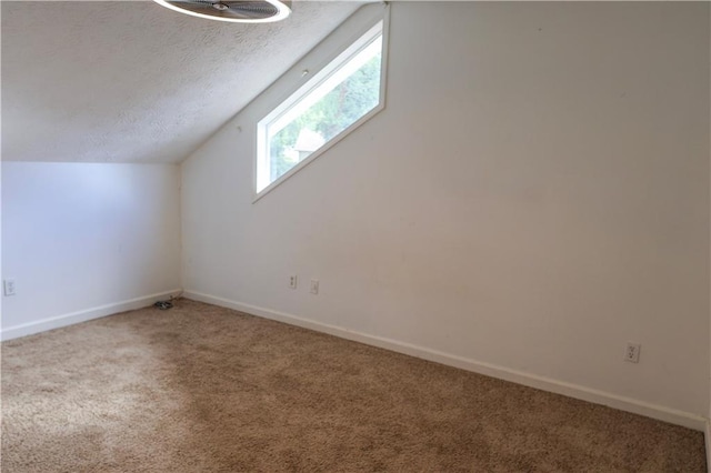 bonus room featuring carpet floors, a textured ceiling, and lofted ceiling