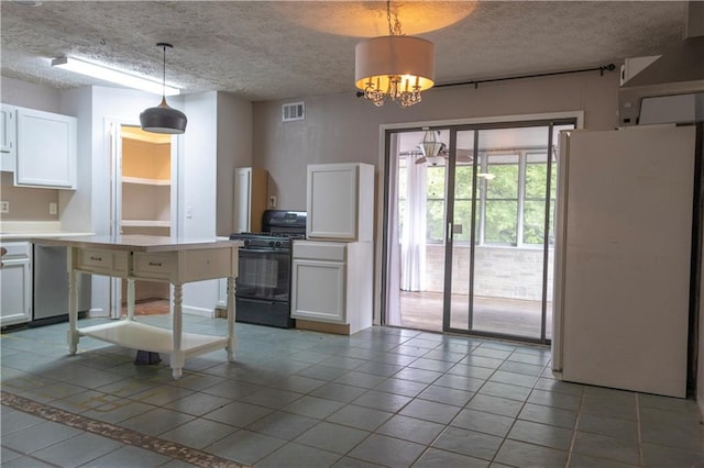 kitchen featuring black gas range oven, white cabinets, white refrigerator, pendant lighting, and a textured ceiling