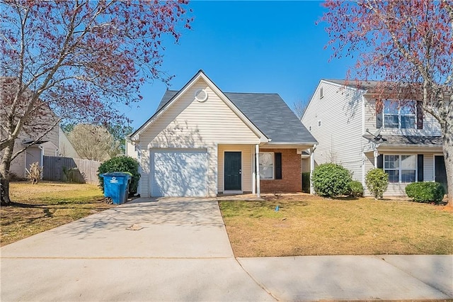 traditional-style house featuring brick siding, a front yard, fence, a garage, and driveway