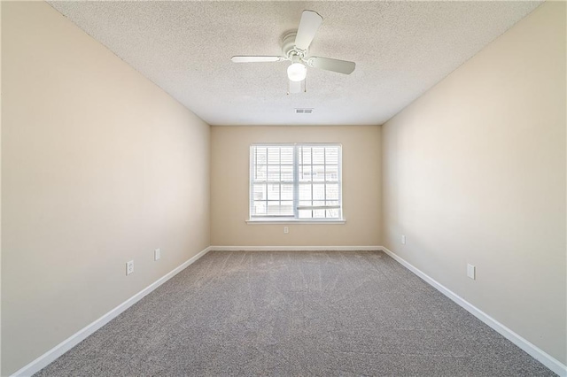 carpeted empty room with a textured ceiling, a ceiling fan, visible vents, and baseboards