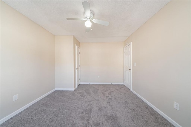 empty room featuring a ceiling fan, carpet, baseboards, and a textured ceiling