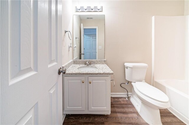 full bath with toilet, wood finished floors, visible vents, vanity, and baseboards