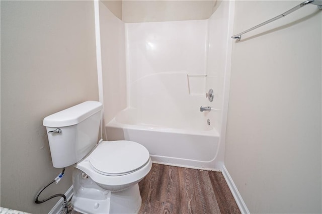 full bathroom featuring toilet, baseboards, tub / shower combination, and wood finished floors