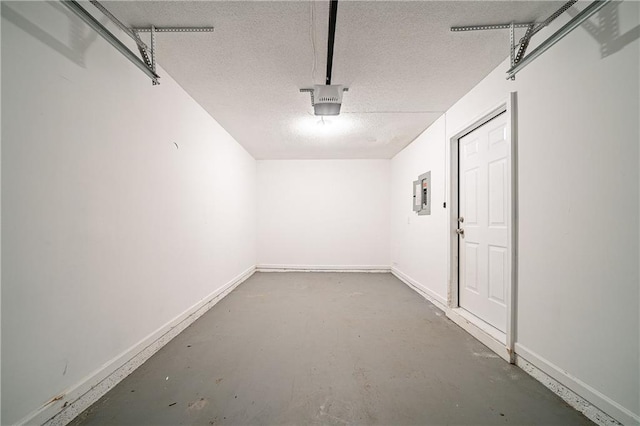 garage with electric panel, baseboards, and a garage door opener