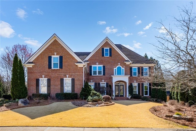 view of front of property with a front lawn and brick siding