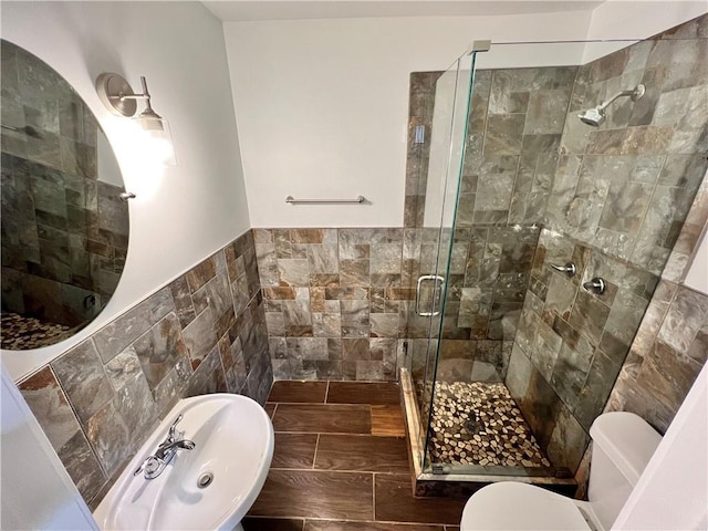 701 Cameron M Alexander Blvd NW, Atlanta, GA 30318 - full bathroom featuring tile walls, a shower stall, toilet, and wainscoting