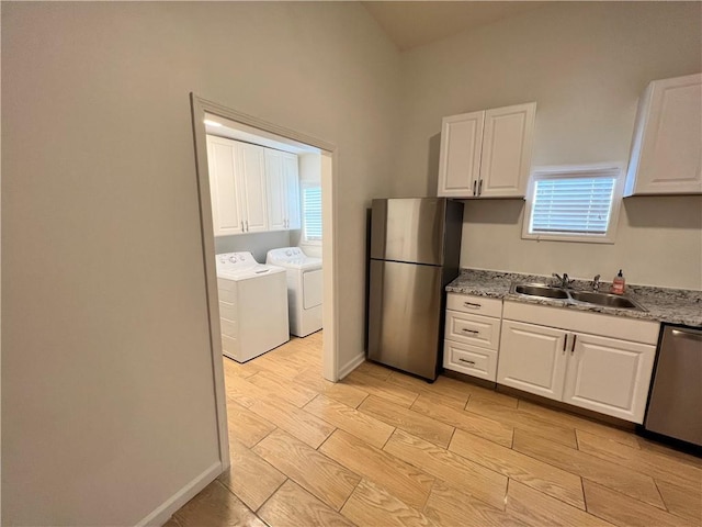 701 Cameron M Alexander Blvd NW, Atlanta, GA 30318 - kitchen featuring stainless steel appliances, a sink, independent washer and dryer, white cabinets, and wood tiled floors