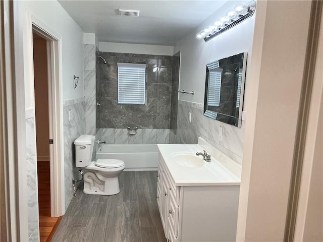 701 Cameron M Alexander Blvd NW, Atlanta, GA 30318 - bathroom featuring tile walls, toilet, vanity, shower / bath combination, and wood finished floors