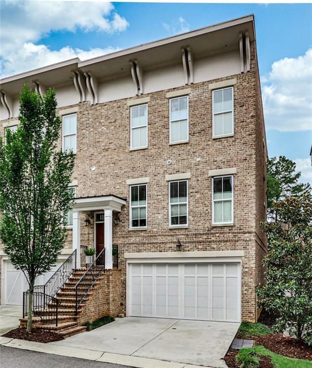 view of front of home featuring concrete driveway, brick siding, and an attached garage