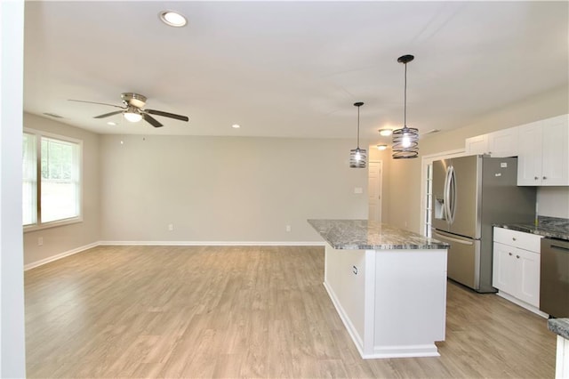 537 Eastside Dr, Dacula, GA 30019 - kitchen featuring stainless steel appliances, a ceiling fan, a center island, white cabinetry, and dark stone countertops