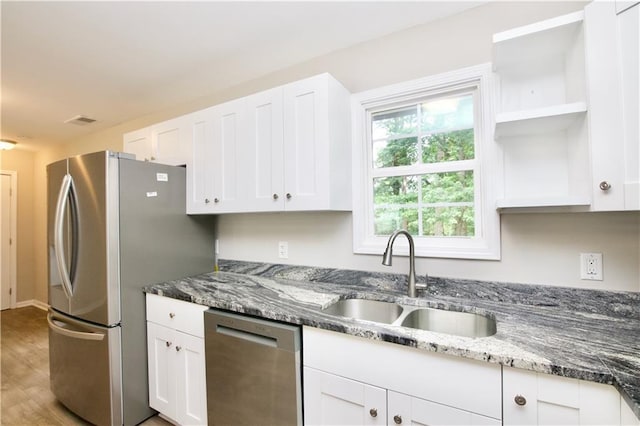 537 Eastside Dr, Dacula, GA 30019 - kitchen featuring stainless steel appliances, a sink, open shelves, and white cabinetry