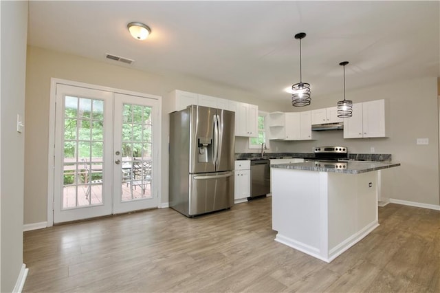 537 Eastside Dr, Dacula, GA 30019 - kitchen featuring stainless steel appliances, under cabinet range hood, white cabinets, light wood finished floors, and baseboards