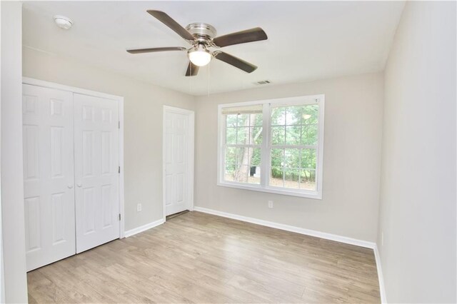 537 Eastside Dr, Dacula, GA 30019 - unfurnished bedroom with baseboards, light wood-style floors, and a ceiling fan