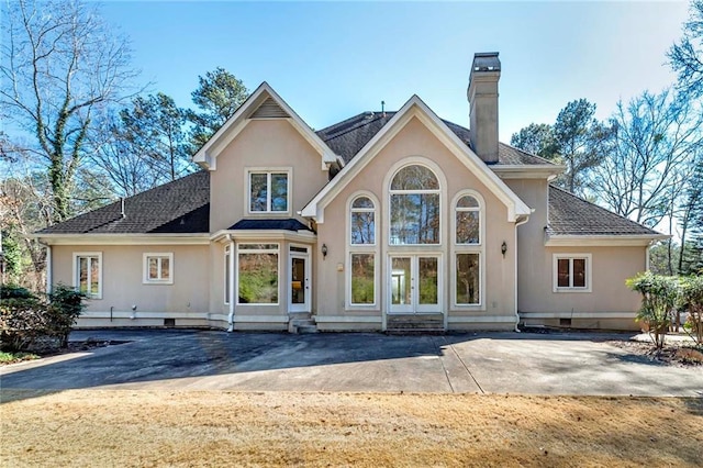 back of house featuring a chimney, entry steps, stucco siding, crawl space, and french doors