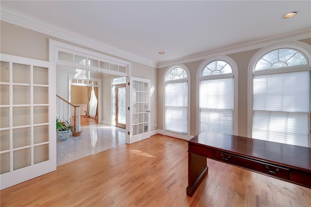 interior space with french doors, baseboards, recessed lighting, wood finished floors, and ornamental molding