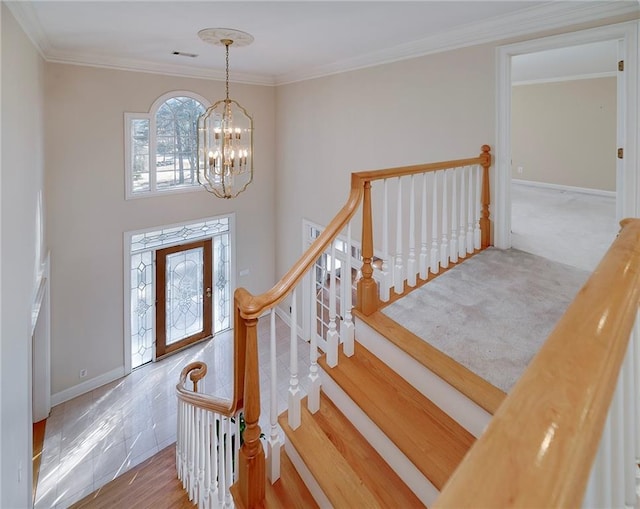 entrance foyer featuring crown molding, baseboards, and an inviting chandelier