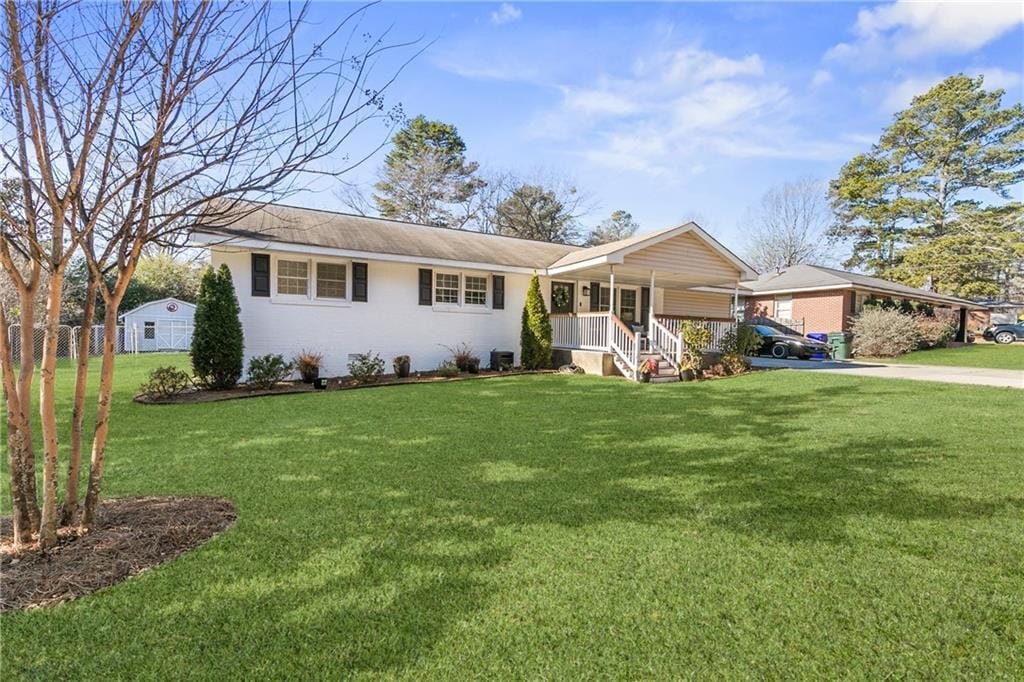 ranch-style home featuring a front yard and covered porch