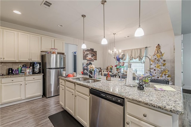 446 Vandenburg Dr, Villa Rica, GA 30180 - kitchen with appliances with stainless steel finishes, a sink, wood finished floors, light stone countertops, and tasteful backsplash
