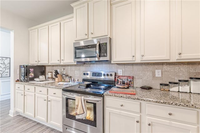 446 Vandenburg Dr, Villa Rica, GA 30180 - kitchen with appliances with stainless steel finishes, backsplash, light stone counters, and light wood finished floors