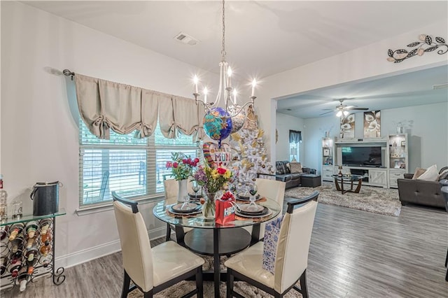 446 Vandenburg Dr, Villa Rica, GA 30180 - dining room featuring wood finished floors, a chandelier, a ceiling fan, and baseboards