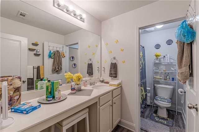 446 Vandenburg Dr, Villa Rica, GA 30180 - full bath with double vanity, toilet, wood finished floors, and a shower with shower curtain