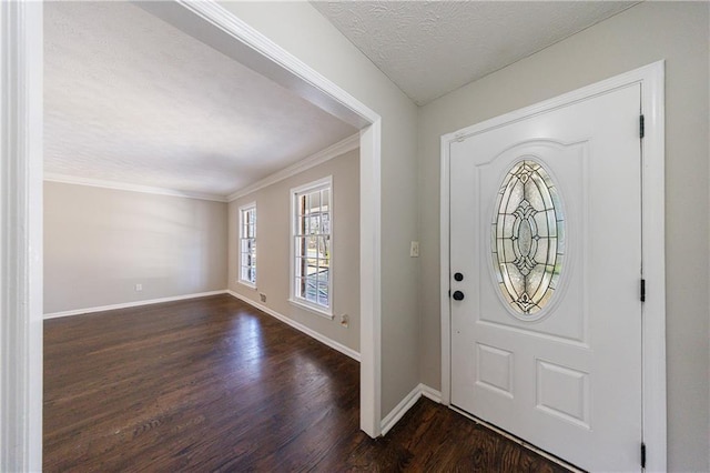 foyer entrance featuring a textured ceiling, crown molding, baseboards, and dark wood-style flooring