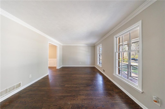 unfurnished room with dark wood-type flooring, crown molding, baseboards, and visible vents