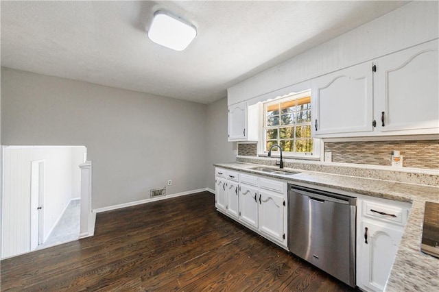 kitchen featuring tasteful backsplash, white cabinets, dishwasher, and a sink