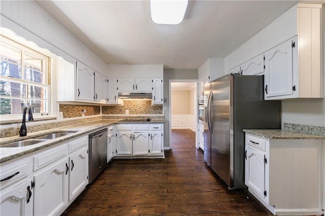 kitchen featuring under cabinet range hood, white cabinets, appliances with stainless steel finishes, and a sink