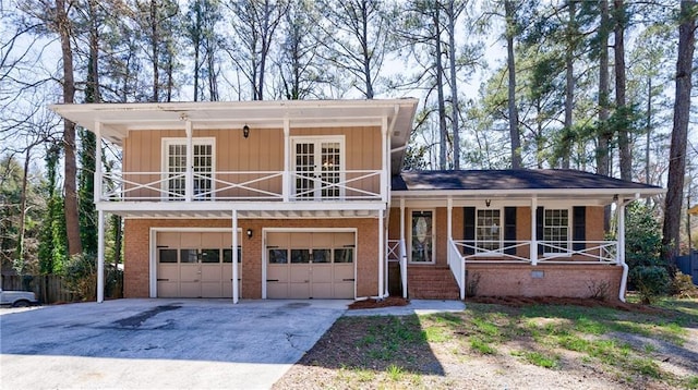 split level home featuring a balcony, driveway, a porch, french doors, and brick siding