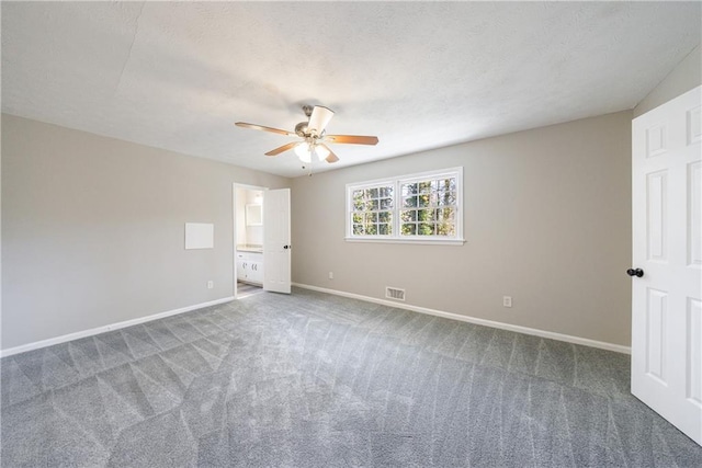 unfurnished bedroom featuring visible vents, a textured ceiling, baseboards, and carpet