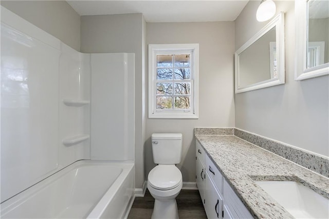 full bathroom with toilet, wood finished floors, vanity, baseboards, and shower / bathtub combination