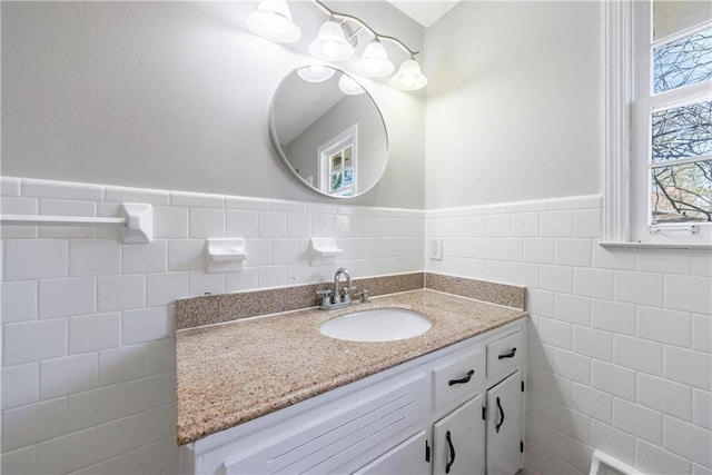 bathroom featuring a wainscoted wall, tile walls, and vanity