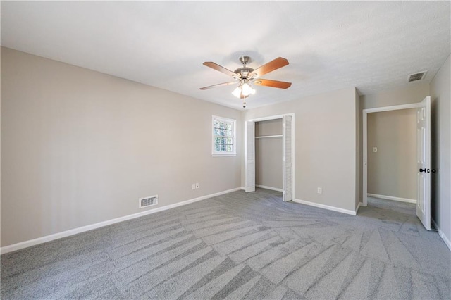 unfurnished bedroom with a closet, visible vents, carpet, and baseboards