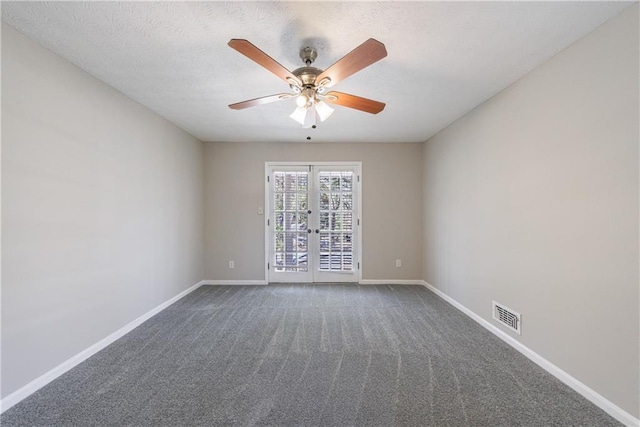 carpeted spare room with a textured ceiling, french doors, visible vents, and baseboards