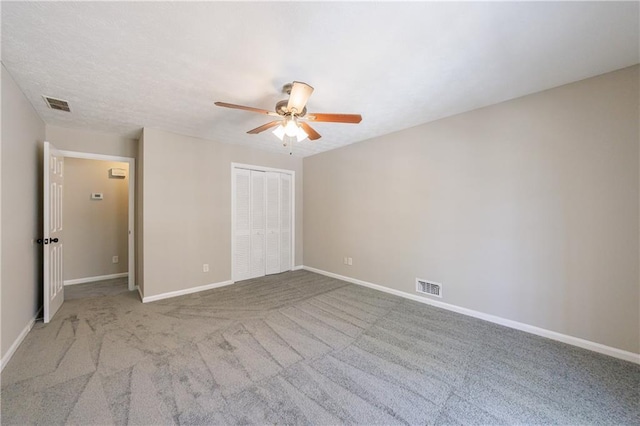 unfurnished bedroom with visible vents, baseboards, carpet floors, and a closet