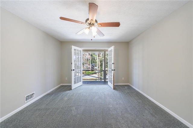 carpeted spare room featuring a textured ceiling, french doors, visible vents, and baseboards