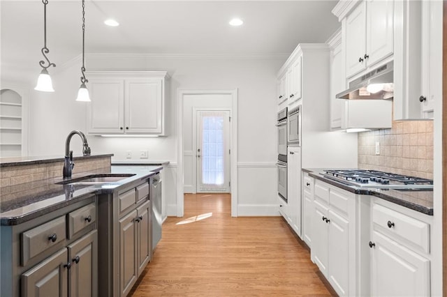 kitchen with light hardwood / wood-style floors, white cabinets, and decorative light fixtures